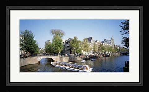 Framed Netherlands, Amsterdam, tour boat in channel Print