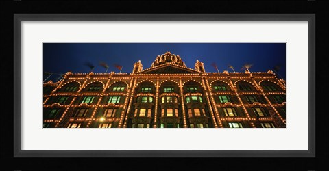 Framed Low angle view of a building lit up at night, Harrods, London, England Print