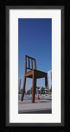 Framed Woman standing under a sculpture of large broken chair, Geneva, Switzerland Print