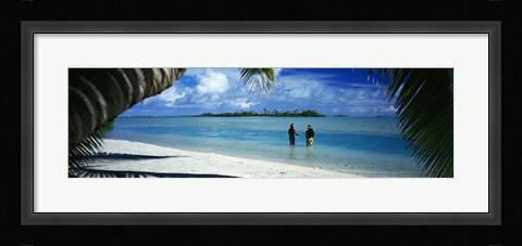 Framed Rear view of two native teenage girls in lagoon, framed by palm tree, Aitutaki, Cook Islands. Print