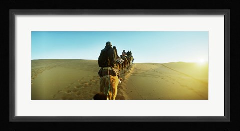 Framed Row of people riding camels through the desert, Sahara Desert, Morocco Print