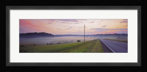 Framed Country road and telephone lines splitting farmlands at dawn, Finland Print
