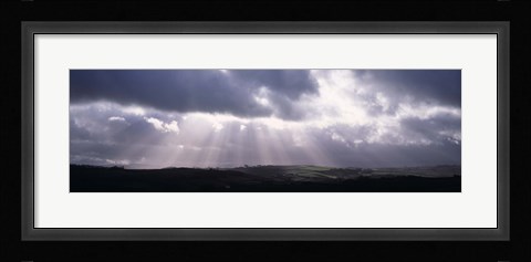 Framed Sunbeams radiating through dark clouds over rolling hills, Dartmoor, Devon, England Print