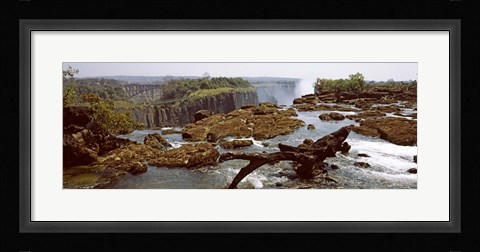 Framed Log on the rocks at the top of the Victoria Falls with Victoria Falls Bridge in the background, Zimbabwe Print