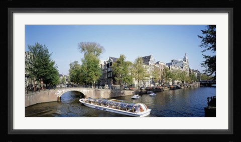 Framed Netherlands, Amsterdam, tour boat in channel Print