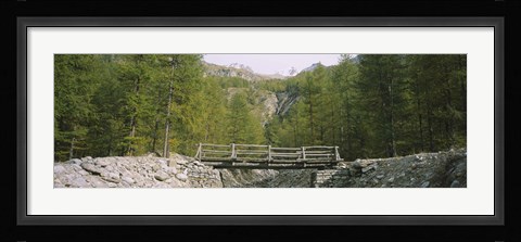 Framed Wooden footbridge across a stream in a mountain range, Switzerland Print
