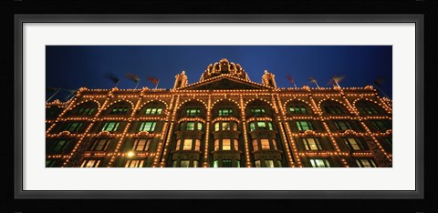 Framed Low angle view of a building lit up at night, Harrods, London, England Print