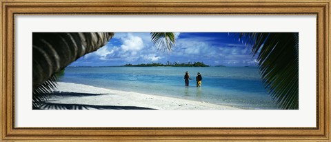 Framed Rear view of two native teenage girls in lagoon, framed by palm tree, Aitutaki, Cook Islands. Print