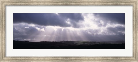 Framed Sunbeams radiating through dark clouds over rolling hills, Dartmoor, Devon, England Print