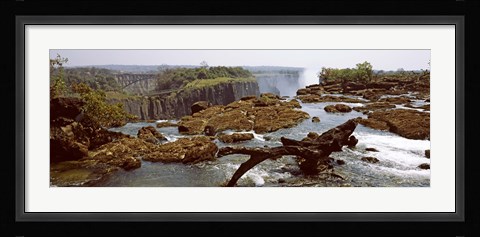 Framed Log on the rocks at the top of the Victoria Falls with Victoria Falls Bridge in the background, Zimbabwe Print