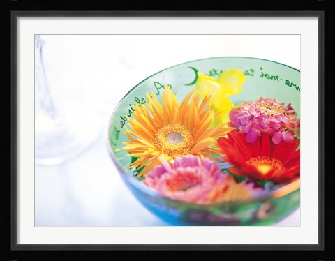 Framed Pink, orange and yellow flowers floating in a blue bowl Print
