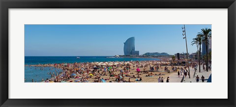 Framed Tourists on the beach with W Barcelona hotel in the background, Barceloneta Beach, Barcelona, Catalonia, Spain Print