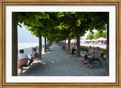 Framed People sitting on benches among trees at lakeshore, Lake Como, Cernobbio, Lombardy, Italy Print