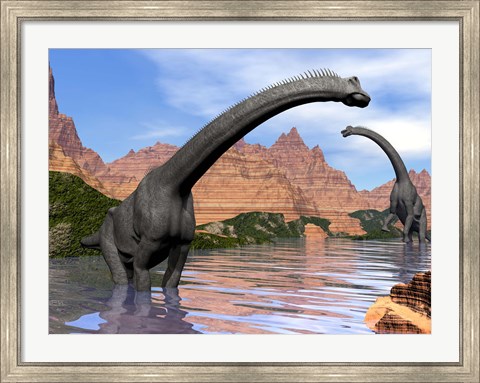 Framed Two Brachiosaurus dinosaurs in water next to red rock mountains Print