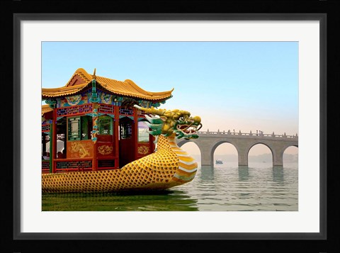 Framed Summer Palace, a traditional Dragon Boat passes the Seventeen Arch Bridge, Kunming lake, Beijing, China Print