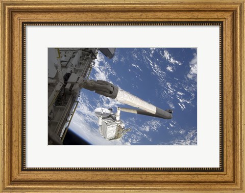Framed Integrated Cargo Carrier in the grasp of the shuttle&#39;s remote manipulator system arm Print